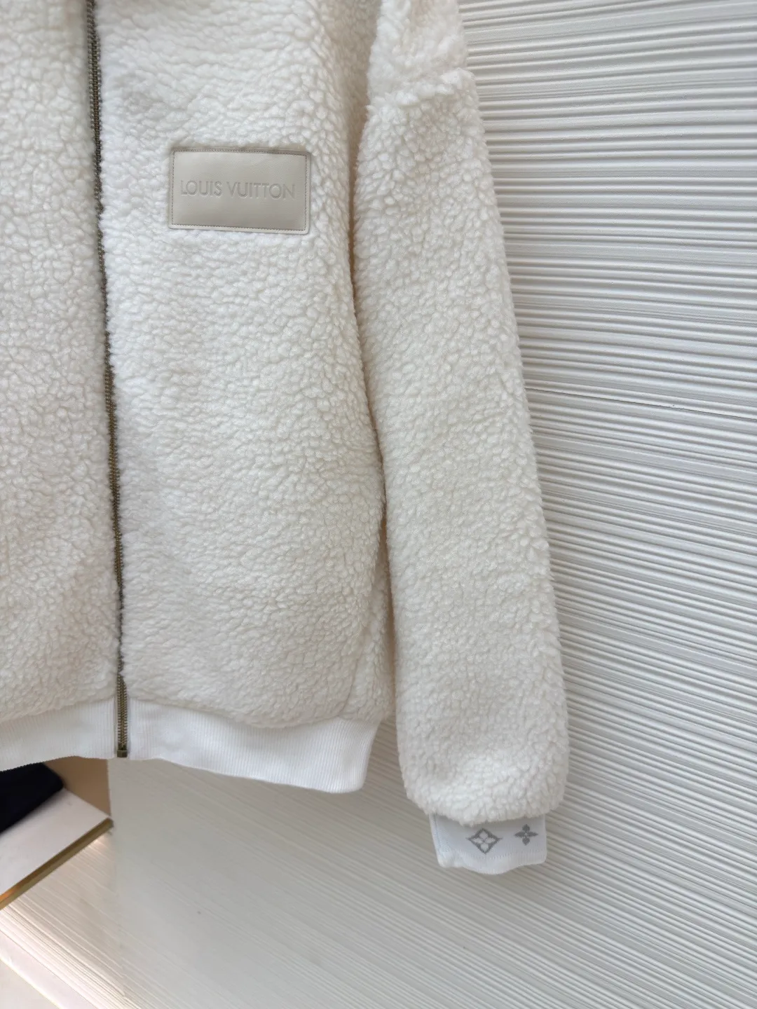 LOUIS VUITTON Teddy sheep wool blended suede tunic jacket ●Authentic product: Purchased and developed by 16841 ●Item number: 1680679-B70 ●Fabric: Lamb wool fabric ●Technology: Positioned cutting machine ●Version: Fitted version ●Weight: about 865 grams ●Size: S-M-L-XL ●Description: Made of high-quality lamb wool fabric, the fluff is fine and soft, rich to the touch, the fluff is tight and even, not easy to shed, ensuring the quality and durability of the jacket; the collar adopts a stand-up collar design, which has been treated with special technology to be stiff and stylish, which can protect the neck from cold wind; the brand on the zipper head The logo is exquisite and compact, adding to the beauty of the details; the brand leather patch on the left chest is made of high-quality material, and the embossed brand logo is clear and three-dimensional, with full texture, which enhances the recognition and high-end sense of the jacket; during the sewing process, the stitches are fine and even, especially the splicing of the lamb wool fabric, which is smooth and firm. The overall wiring is straight and delicate, the fabric is comfortable and soft, and the color is consistent without color difference. It can be matched with the same style to create a fashionable look and control various occasions. Customized accessories, complete with three standards, same style for men and women!